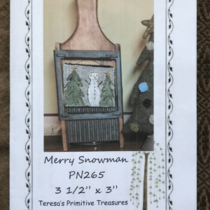May include: A framed, rustic Christmas decoration featuring a snowman and two evergreen trees. The frame is made of wood and metal. The text "Merry Snowman" and "PN265" are visible. The dimensions are 3 1/2" x 3".