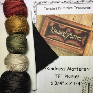 May include: A needlepoint kit with six skeins of embroidery floss in shades of brown, green, beige, and red. The kit includes a piece of white Aida cloth, a piece of black felt, and a pattern for a needlepoint design that reads "Kindness Matters" with a rainbow and flowers. The pattern is 6 3/4 inches by 2 1/4 inches.