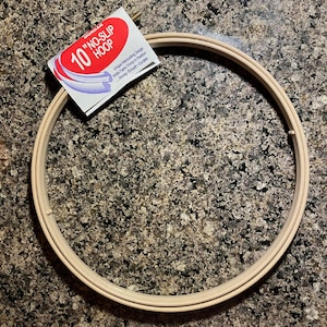 May include: A 10 inch beige embroidery hoop with a white label that reads "Morgan "No-Slip Hoop" Unique Interlocking Design Holds Fabric Firmly in Position Sewing Smooth + Durable"