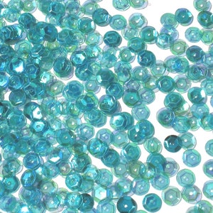 May include: A scattering of turquoise iridescent sequins, ideal for crafting or decorating.