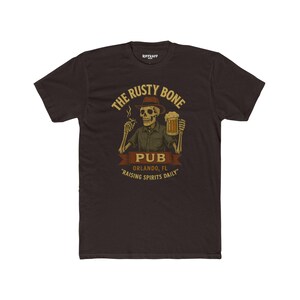 May include: A black t-shirt with a graphic of a skeleton holding a beer and a cigarette. The graphic says "The Rusty Bone Pub, Orlando, FL, "Raising Spirits Daily."