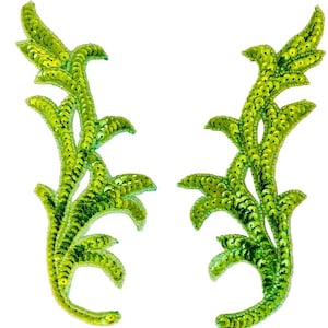 May include: A pair of matching lime green leaf-shaped appliqués covered in shimmering sequins. Each piece features a detailed, branching botanical design with multiple pointed segments, crafted entirely from bright green reflective sequins.
