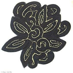 May include: A black and gold beaded floral applique. The applique is made of black cord and gold beads, and features a stylized floral design.