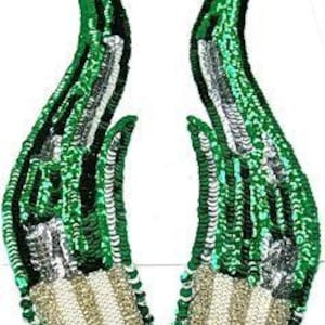 May include: Two green, silver, and black sequined fabric appliques shaped like horns. The horns are approximately 10 inches long.