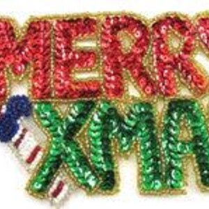 May include: A green and red sequined Christmas ornament with the words "Merry Xmas" and holly leaves.