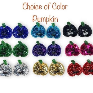 Peut inclure: Une collection d'écussons perlés en forme de citrouille disposés en rangées, avec le texte Choice of Color Pumpkin en haut. Les écussons sont disponibles en plusieurs couleurs dont bleu, turquoise, noir, vert, violet, rose, argent, or et rouge.