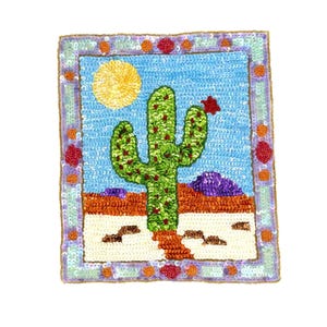 May include: A rectangular patch featuring a sequined desert landscape. A green cactus stands in a sandy foreground under a bright yellow sun and blue sky. The scene is framed by a border of light blue, orange, and red sequins on a gold base.