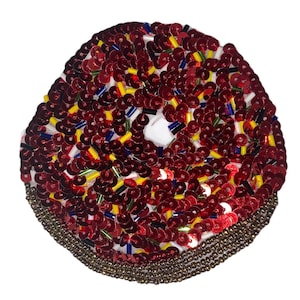 May include: A red, white, blue, and gold sequined donut-shaped patch. The donut is decorated with sequins and beads.