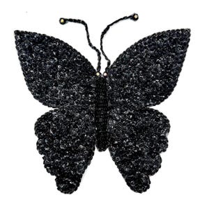 May include: Black sequined butterfly applique with a beaded body and two small rhinestones on the antennae.