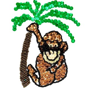 Peut inclure: Un écusson décoratif représentant un singe suspendu à un palmier. Le singe est orné de sequins marron et de perles noires, tandis que le palmier est composé de sequins vert vif. Le singe possède un visage crème et un contour en perles noires.