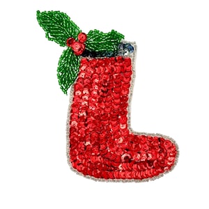 May include: A festive Christmas stocking ornament, covered in red sequins, with a beaded green holly and red berry accent. The stocking is outlined with silver beads, creating a sparkling holiday decoration.