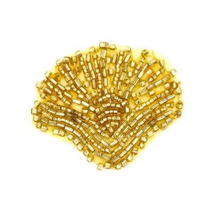 May include: A fan-shaped applique patch featuring intricate gold-toned glass beads and metallic bugle beads arranged in a radiating pattern on a light yellow fabric base. The design consists of rows of cylindrical and round beads.