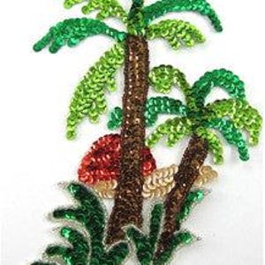 May include: A decorative patch featuring two palm trees with brown sequin trunks and bright green sequin fronds. A red sequin sun sits behind the taller trunk, with a small patch of beige sequins at the base of the trees and green foliage below.