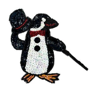 May include: A decorative patch shaped like a penguin wearing a top hat and a red bow tie, crafted with black, white, and iridescent sequins and beads. The penguin holds a thin black cane, features orange feet, and is detailed with red accents.
