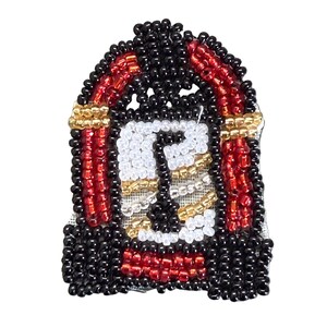 May include: A beaded patch shaped like a jukebox, featuring black, red, white, and gold glass beads. The design includes a central white and gold panel with a black musical note symbol, framed by red and black beaded borders and gold accents.