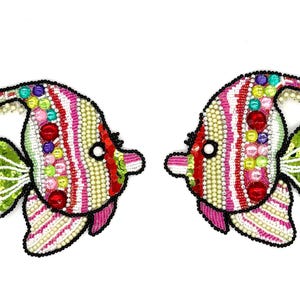 May include: Two decorative fish-shaped patches featuring intricate beadwork and sequins. The fish are designed with vertical stripes in pink, white, and cream, accented by colorful round beads, green sequined fins, and black beaded outlines.