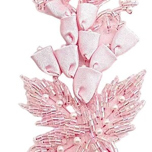 May include: A light pink floral applique featuring fabric ribbon petals arranged in a vertical cluster, accented with clear glass seed beads and small white pearls. The lower section consists of beaded leaves with a textured, shimmering finish.