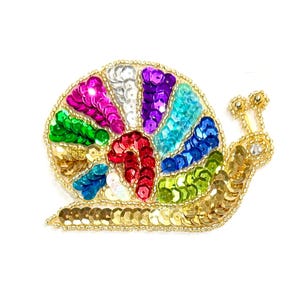 May include: A snail-shaped patch featuring a multi-colored sequin shell with segments of magenta, silver, purple, turquoise, blue, green, and red. The body of the snail is crafted from gold sequins and beads, with two antennae topped with gold beads.