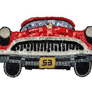 May include: A beaded and sequined patch shaped like the front of a vintage red car. The design features a black grille, silver headlights, and a yellow license plate with the number 53. The surface is covered in red, black, silver, and yellow beads.