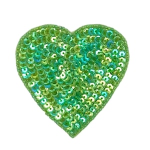 May include: A heart-shaped embellishment covered in iridescent green sequins. The sequins are tightly packed, creating a shimmering effect. The heart is a vibrant shade of green, perfect for adding sparkle to crafts or clothing.
