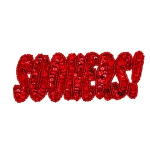 May include: Red sequined text that reads "SOONERS!" against a white background. The letters are in a cursive style and are densely covered in shiny red sequins. The exclamation point is also sequined.