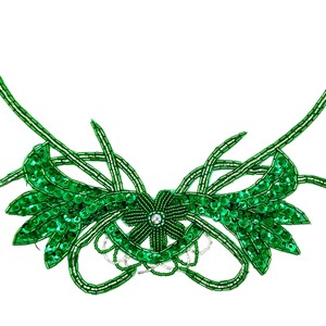 May include: A decorative applique featuring vibrant green beads and sequins arranged in a symmetrical floral and leaf pattern. The design includes a central flower with a single clear rhinestone, surrounded by curved beaded stems and foliage.