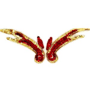 May include: A decorative sequin applique in a symmetrical design. The applique features a central cluster of red sequins, with curving wings outlined in gold sequins. The design is set against a white background.