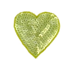 May include: A lime green heart-shaped sequin patch. The patch is covered in small, round sequins and has a stitched border. The sequins reflect light, creating a shimmering effect. This decorative patch is perfect for adding flair to clothing or accessories.