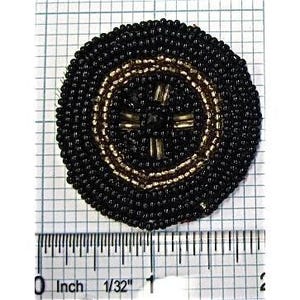 May include: A round, black beaded pin with a gold and black circular design. The pin has a cross-like pattern in the center. The pin is approximately 1 inch in diameter.