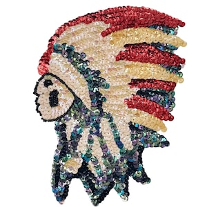 May include: A sequined Native American headdress patch. The patch features a profile view with a cream-coloured face, a red and gold feathered crown, and a base of iridescent blue, green, and black sequins. The design is on a white background.