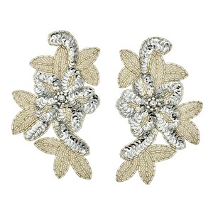 May include: A pair of floral appliques featuring silver sequins arranged in a flower shape, surrounded by light gold beaded leaves. The intricate design uses metallic silver sequins for the petals and fine gold beads to outline the foliage.