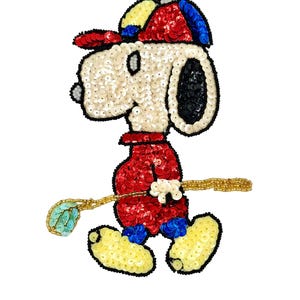 May include: A decorative patch featuring a cartoon dog character wearing a red, yellow, and blue baseball cap and a red shirt. The character is holding a golf club with a light blue head. The entire design is crafted with colourful sequins.