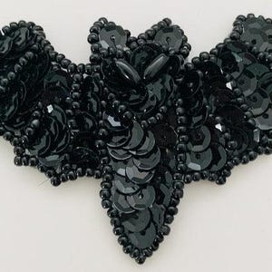 May include: Black sequined bat applique. This is a decorative embellishment for clothing, crafts, or home decor.