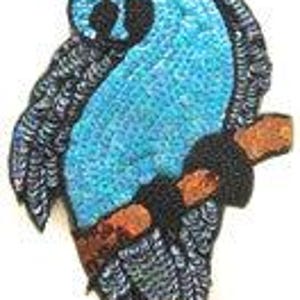 May include: A blue and black sequined parrot applique patch with a brown branch. The parrot is perched on the branch with its wings spread out.