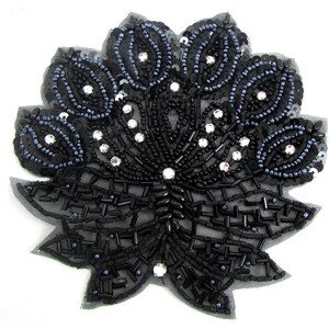 May include: Black beaded applique with a floral design. The applique features black sequins, beads, and clear rhinestones. The design is on a black mesh backing, creating a decorative embellishment for clothing or crafts.