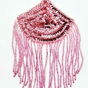 May include: A pink sequin and bead applique with a fan-shaped design. The top portion is densely covered in small, round sequins, while the bottom features long beaded fringe. The applique is likely for embellishing clothing or accessories.