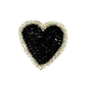 May include: A heart-shaped patch with a black sequined centre and a silver beaded border. The patch is designed to be sewn or ironed onto fabric, adding a decorative element to clothing or accessories.