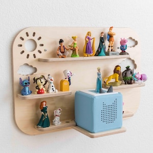 May include: A wooden wall shelf with a sun and clouds design, featuring multiple shelves for displaying small toys and figurines. The shelf is painted in a light wood color and has a blue speaker on the bottom shelf.
