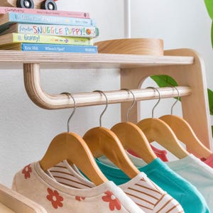 Close up of a kids closet showing the heigh quality of the clothes hanging rack. The wardrobe is made from Baltic Birch wood.