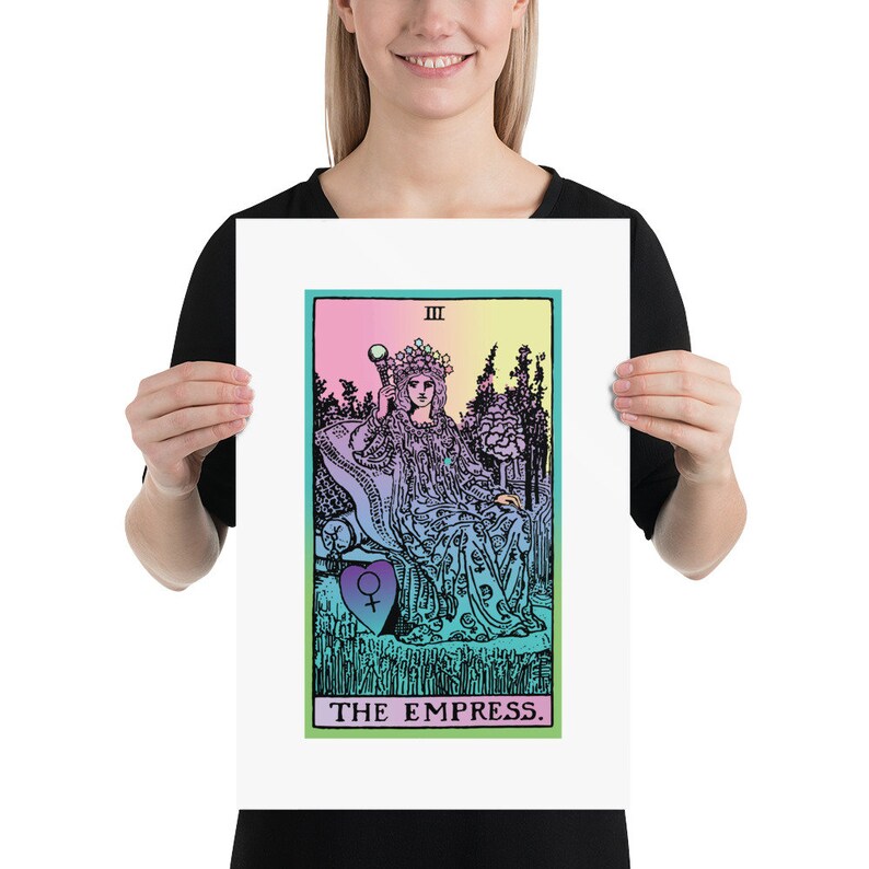 May include: A framed print of The Empress tarot card. The artwork features a seated woman with a crown, holding a scepter, set against a colorful background. The card is bordered in green, with the title "THE EMPRESS" at the bottom.
