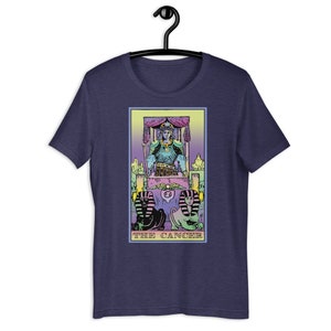 Puede incluir: Una camiseta azul marino con una ilustraci&oacute;n en colores pastel de la carta del tarot El C&aacute;ncer. La carta presenta una figura sentada en un trono con dos figuras de esfinge en la parte inferior.