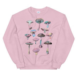 May include: A pink sweatshirt with a colorful mushroom graphic print. The mushrooms are arranged in a cluster and have different shapes and sizes.