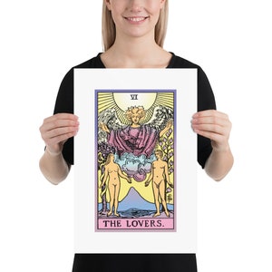 May include: The Lovers tarot card features a colourful illustration of a winged angel above two nude figures standing on either side of a mountain. The card is labelled "VI" and "THE LOVERS."