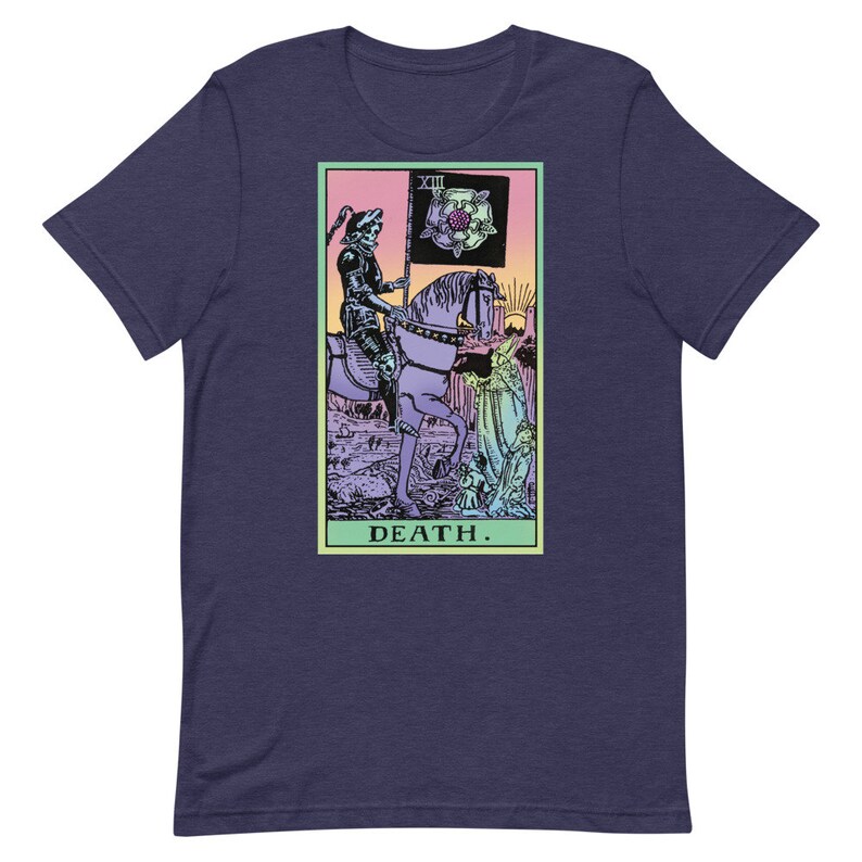 Puede incluir: Camiseta azul marino con un dise&ntilde;o de carta del tarot. El gr&aacute;fico representa una figura esquel&eacute;tica a caballo, sosteniendo una bandera con una rosa. La palabra "DEATH" est&aacute; impresa debajo. El dise&ntilde;o est&aacute; en un marco rectangular.