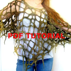 Peut inclure: Un poncho en feutre vert à mailles ouvertes avec des bords effilochés. Le poncho est porté par une personne aux cheveux longs et bruns. Le texte "PDF TUTORIAL" est visible sur le poncho.