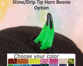Könnte beinhalten: Schwarze Mütze mit einem grünen Glitzer-Schleimhorn. Wählen Sie Ihre Farbe aus der Auswahl an Glitzerfarben.