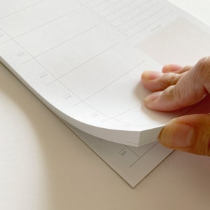 Peut inclure: Un agenda hebdomadaire blanc avec une section &agrave; onglets pour chaque jour de la semaine, y compris lundi, mardi, mercredi, jeudi, vendredi, samedi et dimanche. L'agenda est ouvert aux pages samedi et dimanche.