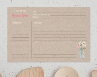 May include: A recipe card with the text "A Recipe For Anna Grace" in pink script. The card is tan with lines for ingredients and directions. A watercolor illustration of flowers in a jar is in the corner.