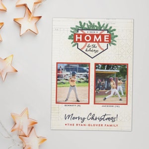 May include: A baseball-themed holiday card with two photos of children playing baseball. The card features the text "HOME for the holidays" and "Merry Christmas!" with the family name. The design includes a baseball diamond shape and green accents.