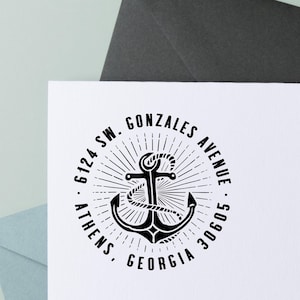May include: A black and white round stamp featuring an anchor design with the text "GONZALES AVENUE", "ATHENS, GEORGIA", and the address "6124 SW. 30605". The stamp is on a white surface.
